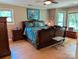 Spacious bedroom featuring a decorative wood bed frame, ample natural light, and hardwood flooring at 5908 Tanson Trl, Marshville, NC 28103