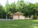 Well-maintained two-car garage with brick facade and lush green lawn with mature trees in the background at 5908 Tanson Trl, Marshville, NC 28103