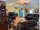 Inviting living room with hardwood floors, beamed ceiling, brick fireplace, and comfortable leather furniture at 5908 Tanson Trl, Marshville, NC 28103