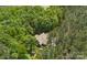 Aerial view of a home surrounded by dense green trees, featuring a fire pit and long driveway at 6599 Majestic Pine Dr, Vale, NC 28168