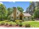 Charming home with a stone chimney, arched entryway, and manicured landscaping at 6599 Majestic Pine Dr, Vale, NC 28168
