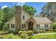 Charming home with a stone chimney, arched entryway, and manicured landscaping at 6599 Majestic Pine Dr, Vale, NC 28168