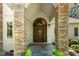 Covered front porch featuring stone pillars and a beautiful arched wood front door at 6599 Majestic Pine Dr, Vale, NC 28168