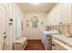 Bright laundry room with patterned wallpaper, storage cabinets, bench, and washer/dryer at 6599 Majestic Pine Dr, Vale, NC 28168