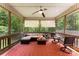 Inviting screened porch with comfortable seating area, ceiling fan, and a view of the surrounding nature at 6599 Majestic Pine Dr, Vale, NC 28168