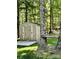 Backyard shed with painted floral design and a wooden tree stand nestled in a forest at 6599 Majestic Pine Dr, Vale, NC 28168