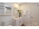 Clean bathroom with a white vanity, decorative mirror, and ample storage at 721 Governor Morrison St # 520, Charlotte, NC 28211