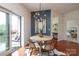 Bright dining area with modern lighting, balcony access, and a view into the bedroom, and hardwood floors at 721 Governor Morrison St # 520, Charlotte, NC 28211