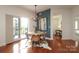 Dining area featuring a modern light fixture, balcony access, and hardwood floors, plus a bedroom view at 721 Governor Morrison St # 520, Charlotte, NC 28211