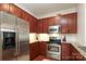 This kitchen features stainless steel appliances, wooden cabinets, tile backsplash, and granite countertops at 721 Governor Morrison St # 520, Charlotte, NC 28211