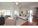 Bright living room featuring a ceiling fan, hardwood floors, a white sofa, balcony access, and large windows at 721 Governor Morrison St # 520, Charlotte, NC 28211