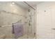 Tiled shower with glass door, built-in shelving, and grab bar for safety at 721 Governor Morrison St # 520, Charlotte, NC 28211