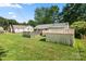 A large grassy backyard featuring a wooden deck and a small storage shed at 728 Dedmon Dr, Charlotte, NC 28216