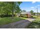 Well-maintained single-story home with a paved driveway and mature trees surrounding the property at 728 Dedmon Dr, Charlotte, NC 28216