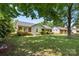 Quaint single-story home featuring brick accents, light blue siding, shuttered windows, and mature trees at 728 Dedmon Dr, Charlotte, NC 28216