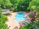 Inviting community pool area with lounge chairs and shaded seating, surrounded by verdant trees at 803 Lake Club Dr, Rock Hill, SC 29732