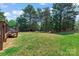Spacious backyard with lush green grass surrounded by mature trees at 8211 Abbottsgate Ln, Charlotte, NC 28269