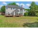 Expansive backyard featuring well-maintained lawn, wooden decks, and home exterior at 8211 Abbottsgate Ln, Charlotte, NC 28269