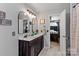 Modern bathroom featuring a dual sink vanity, arched mirrors with sconces, and tiled floors at 8211 Abbottsgate Ln, Charlotte, NC 28269