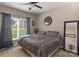 Cozy bedroom featuring natural light, a ceiling fan, and a decorative clock at 8211 Abbottsgate Ln, Charlotte, NC 28269