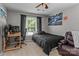 Cozy bedroom featuring neutral paint, ceiling fan, large window, and comfortable furniture arrangement at 8211 Abbottsgate Ln, Charlotte, NC 28269