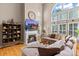 Spacious living room with a fireplace, a wall of windows, and hardwood floors at 8211 Abbottsgate Ln, Charlotte, NC 28269