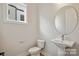 Powder bathroom features a round mirror, pedestal sink, and modern toilet at 842 Van Every St, Charlotte, NC 28205