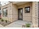 Charming brick entryway with a modern black door, stone landscaping and well-maintained shrubbery at 842 Van Every St, Charlotte, NC 28205