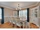 Elegant dining room with a large wooden table, white chairs, and natural light at 8525 Castlekeep Rd # 26, Charlotte, NC 28226