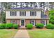 Charming two-story brick home with manicured landscaping, black shutters, and inviting entryway at 8525 Castlekeep Rd # 26, Charlotte, NC 28226