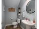 Charming half bathroom with pedestal sink, decorative shelves, and a round mirror at 8532 Westmoreland Lake Dr, Cornelius, NC 28031