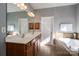 Bathroom featuring double sinks, hardwood cabinets and a soaking tub at 8532 Westmoreland Lake Dr, Cornelius, NC 28031
