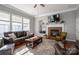 Cozy living room with a fireplace, TV, plush seating and lots of natural light at 8532 Westmoreland Lake Dr, Cornelius, NC 28031