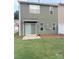 Backyard featuring a green lawn, a sliding door, and a small patio at 9340 Grand Valley Dr, Charlotte, NC 28213