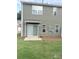 Backyard featuring a green lawn, a sliding door, and a small patio at 9340 Grand Valley Dr, Charlotte, NC 28213