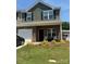 Charming two-story townhome features a well-manicured lawn and covered front porch with seating at 9340 Grand Valley Dr, Charlotte, NC 28213
