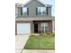 Charming two-story home featuring a brick facade, attached garage, and well-maintained lawn at 9340 Grand Valley Dr, Charlotte, NC 28213