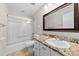 Bathroom featuring large mirror, granite counters, white cabinets, and shower/tub at 9640 Heartwood Ln, Mint Hill, NC 28227
