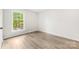 Neutral bedroom featuring modern vinyl flooring, large window, and crisp white walls at 9640 Heartwood Ln, Mint Hill, NC 28227
