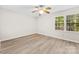 Bright bedroom featuring modern vinyl flooring, large window, and ceiling fan at 9640 Heartwood Ln, Mint Hill, NC 28227