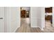 Inviting hallway with hardwood floors, leading to a living room with a brick fireplace at 9640 Heartwood Ln, Mint Hill, NC 28227