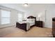 Cozy bedroom featuring a dark wood bed frame, matching dressers, and bright windows at 10205 Alouette Dr, Waxhaw, NC 28173