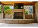 Outdoor brick fireplace with a mounted TV and decorative lanterns at 10205 Alouette Dr, Waxhaw, NC 28173