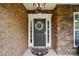 Charming front door with brick and stone accents, elegant wreath, and stylish exterior lighting at 10205 Alouette Dr, Waxhaw, NC 28173