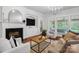 Bright living room with a fireplace, built-in shelving, large windows, and hardwood floors at 10205 Alouette Dr, Waxhaw, NC 28173