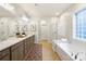 Luxury main bathroom featuring a soaking tub, glass enclosed shower, and double sink vanity at 10205 Alouette Dr, Waxhaw, NC 28173