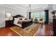 Spacious main bedroom with tray ceiling, hardwood floors, a chandelier, and lots of natural light at 10205 Alouette Dr, Waxhaw, NC 28173