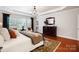 Large main bedroom boasts hardwood floors, a tray ceiling, and large windows with outdoor views at 10205 Alouette Dr, Waxhaw, NC 28173