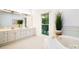 Bright, clean bathroom with double vanity, tub, and large window with backyard views at 1245 Bellemeade Ln, Charlotte, NC 28270