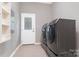Spacious laundry room with tiled floors, modern appliances, and access to the exterior at 1245 Bellemeade Ln, Charlotte, NC 28270